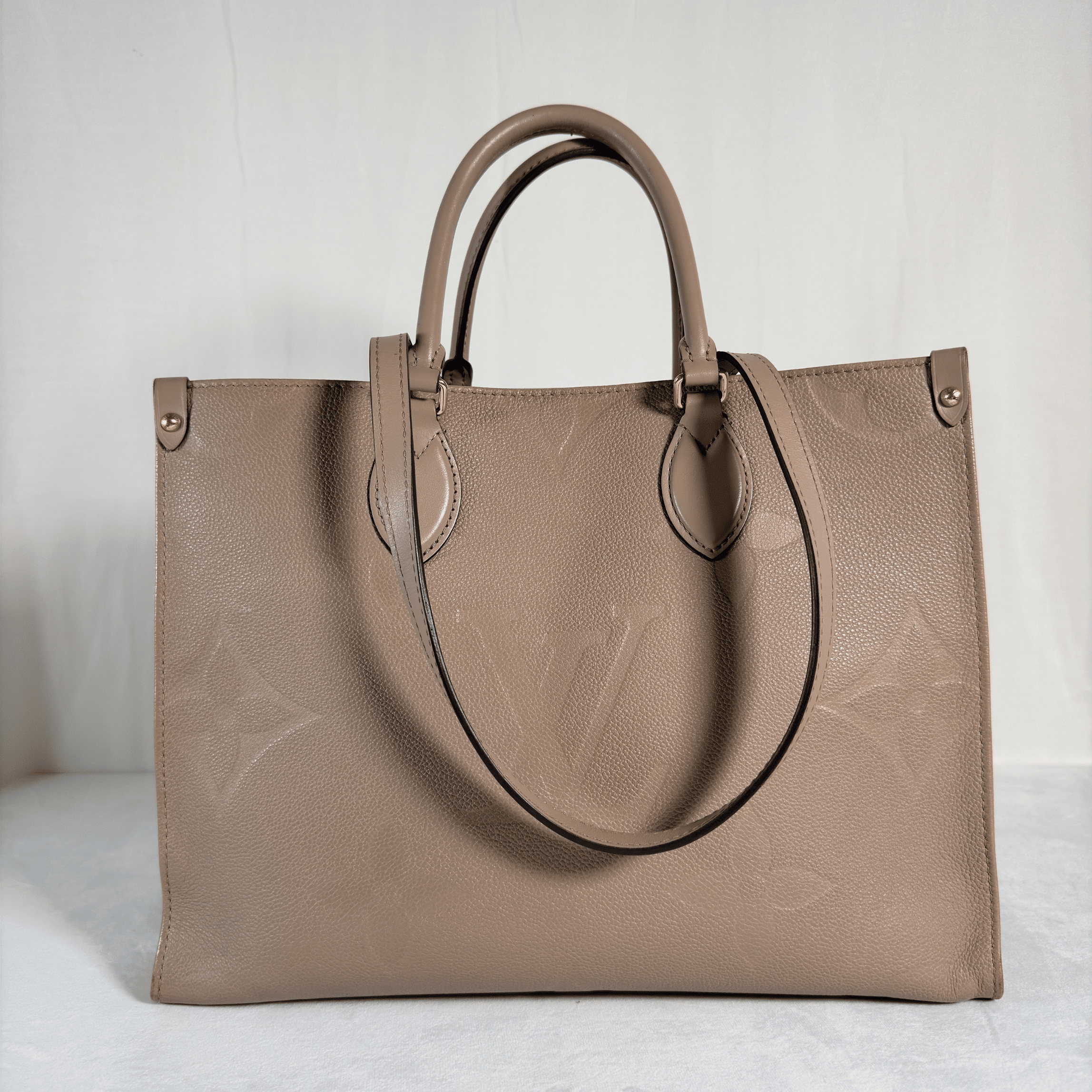 CABAS LOUIS VUITTON ONTHEGO MM - CUIR MONOGRAM EMPREINTE TOURTERELLE - La Belle Boutique