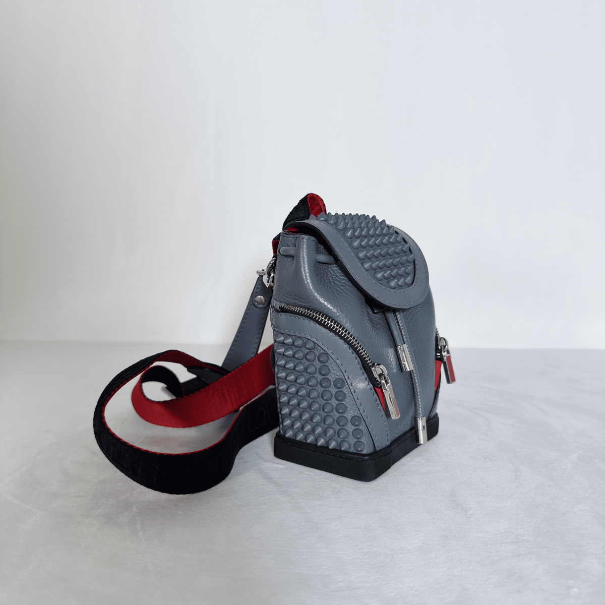 CHRISTIAN LOUBOUTIN - MINI SAC À DOS EXPLORAFUNK - CUIR GRAINE GRIS ET SPIKES - La Belle Boutique