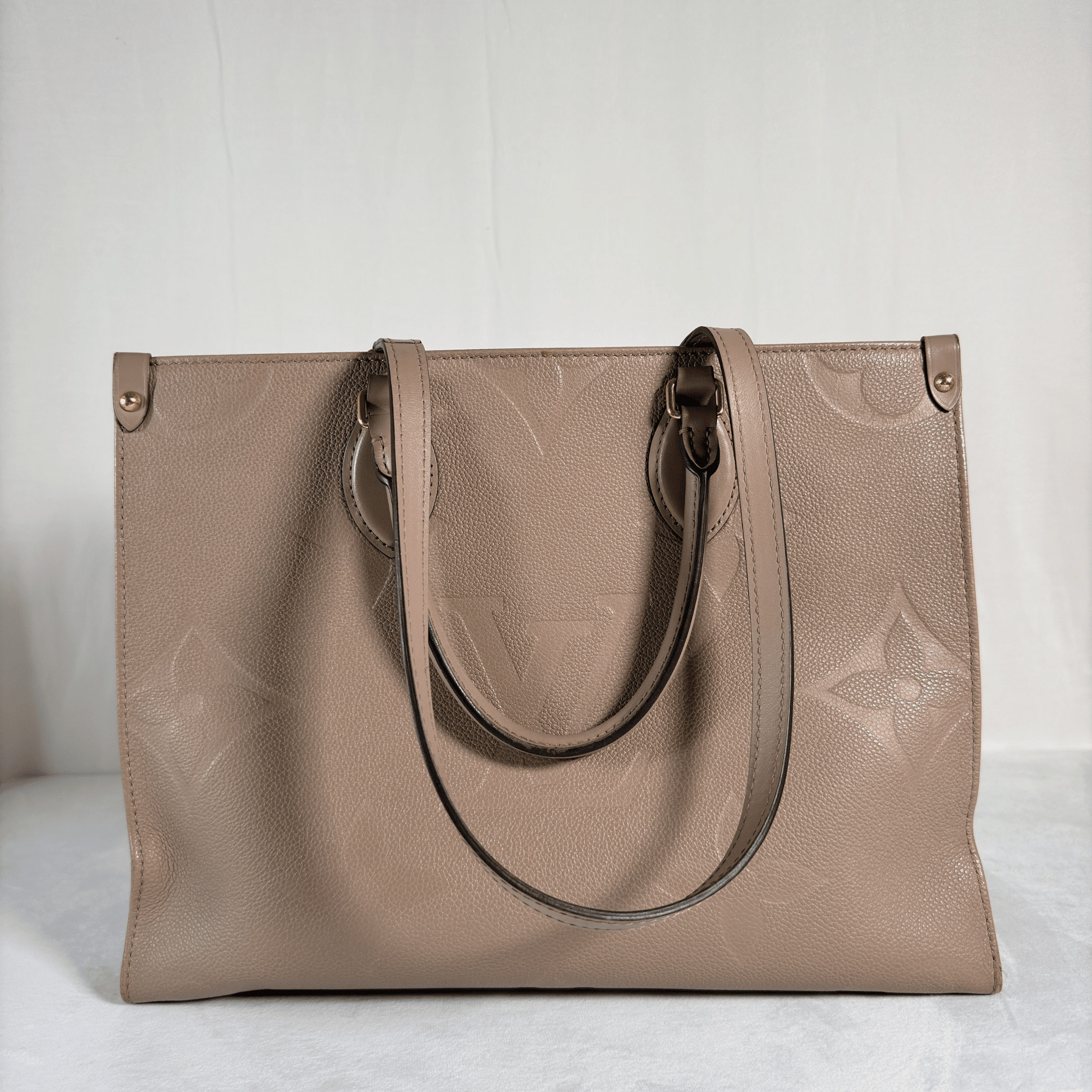 CABAS LOUIS VUITTON ONTHEGO MM - CUIR MONOGRAM EMPREINTE TOURTERELLE - La Belle Boutique