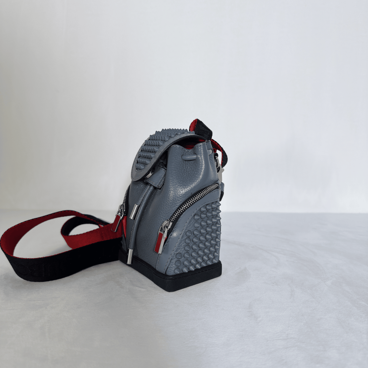 CHRISTIAN LOUBOUTIN - MINI SAC À DOS EXPLORAFUNK - CUIR GRAINE GRIS ET SPIKES - La Belle Boutique